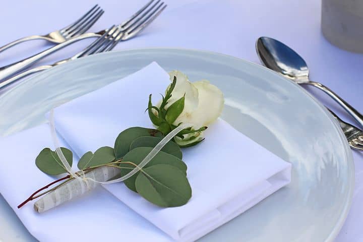 Dinner table setting plate with white rose