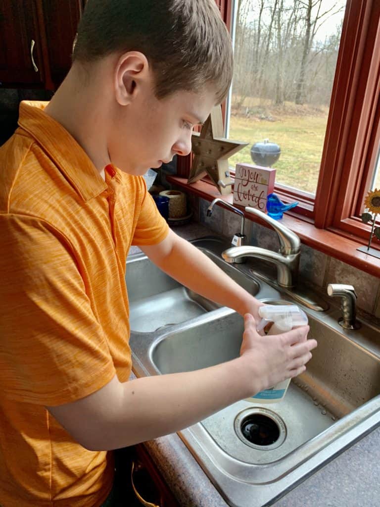 Boy cleaning stainless steel kitchen sink