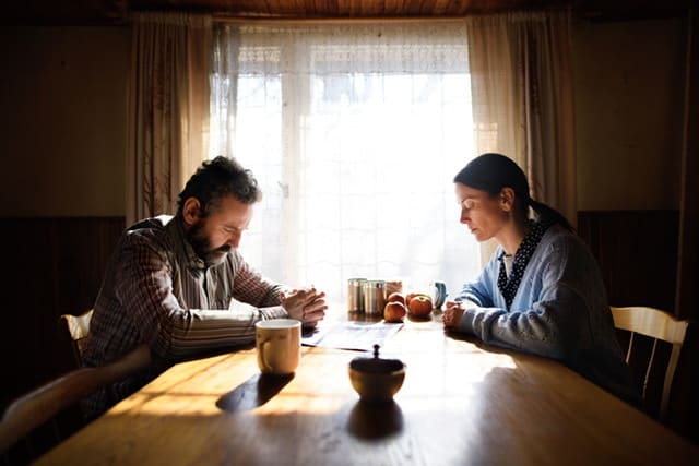 rouple sitting at table praying