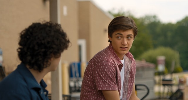 Teen boy talking to another boy outside of school