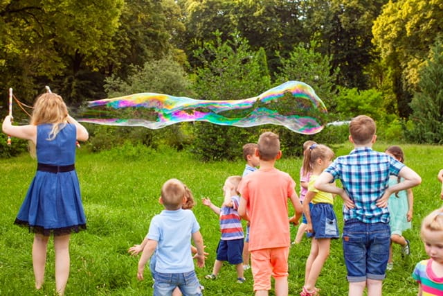 children blowing huge bubbles