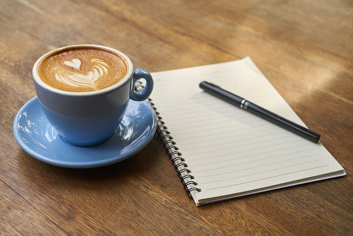 cup of coffee and note pad and pen
