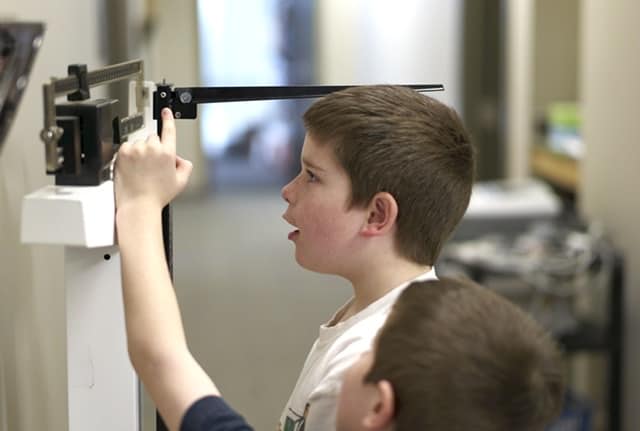 Boy getting weighed and height measured at the doctors office