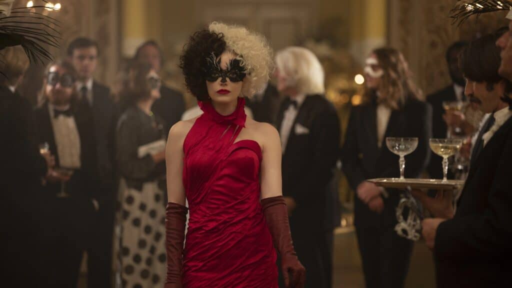 Emma Stone as Cruella in a stunning red dress. Christian movie review of Disney Cruella.