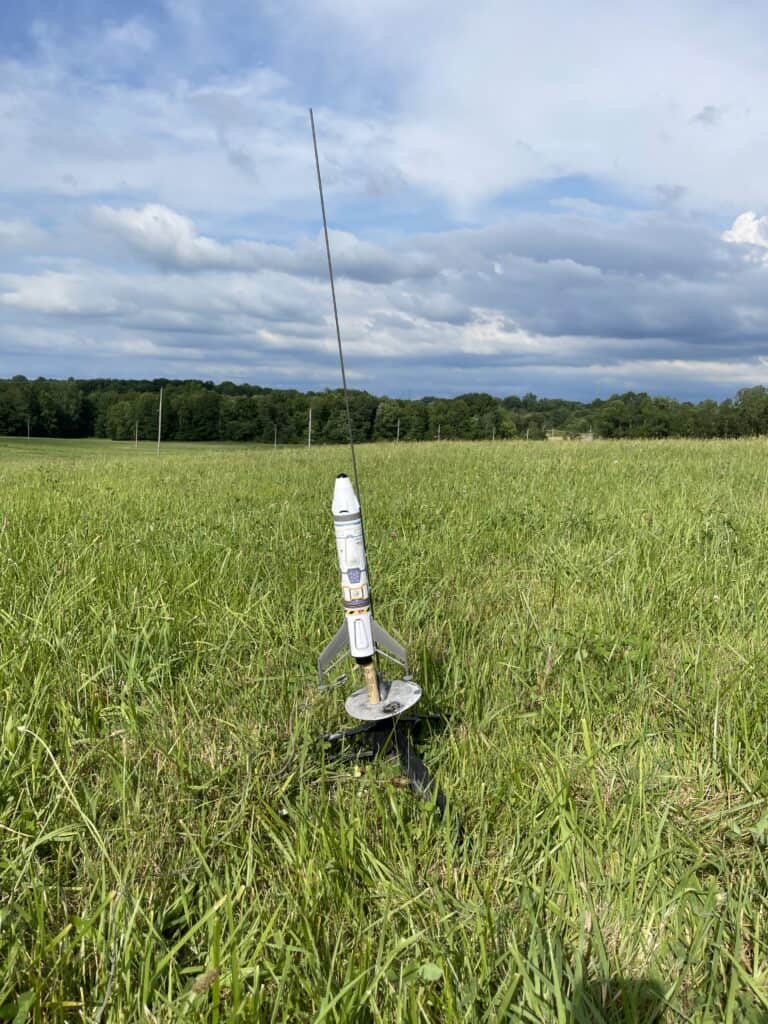 Model Rocket on a launchpad in the middle of a field