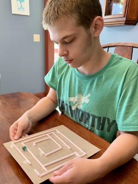 Boy playing with a homemade maze - fun science experiments