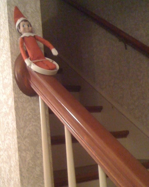 Elf on the Shelf sliding down the banister
