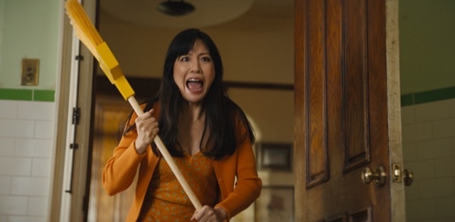 woman holding a broom and screaming