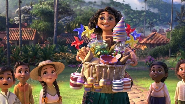 Mirabel holding toys from the Disney Movie Encanto with children surrounding her