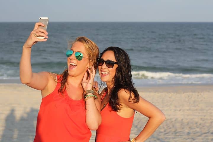 Two teens taking selfies at the beach