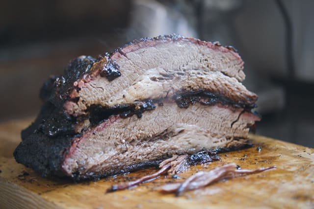 beef brisket cooked sitting on a wooden board