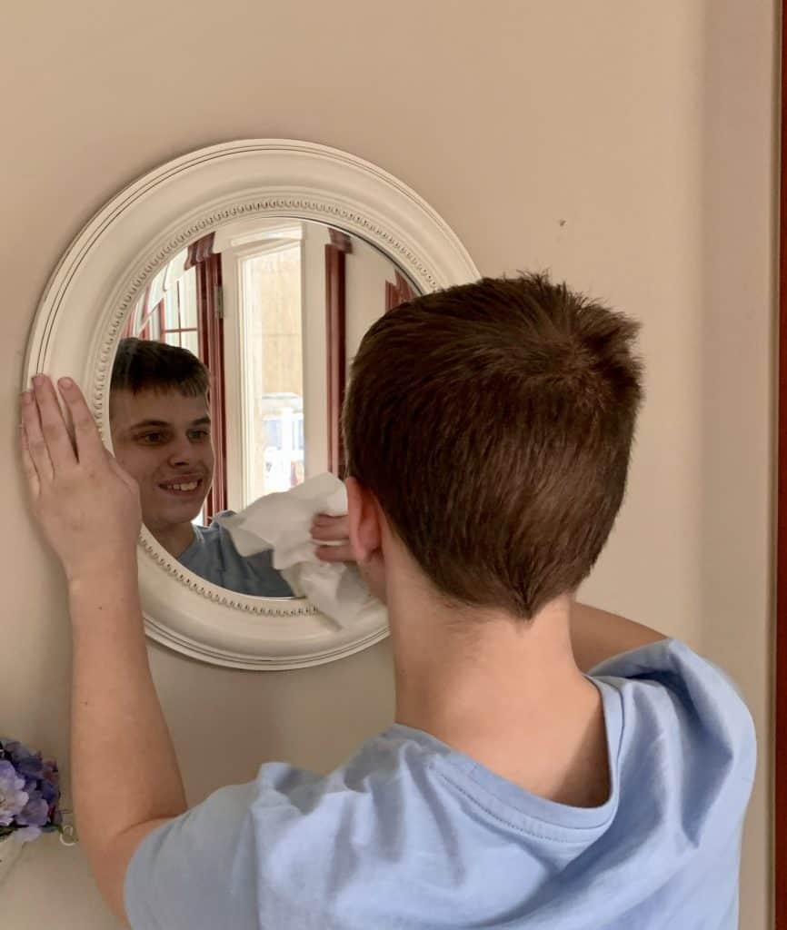 Boy cleaning mirror
