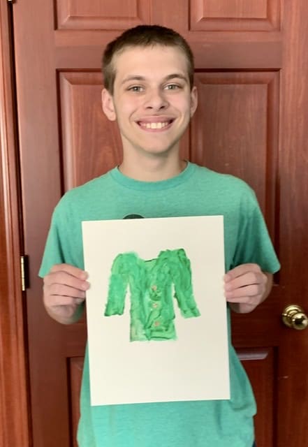 Boy holding painting of a green coat
