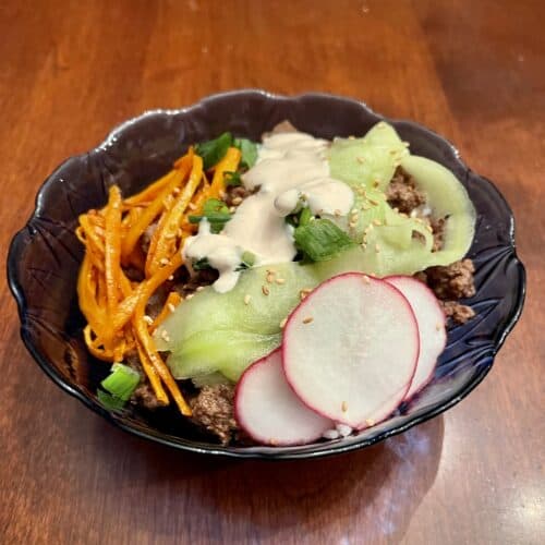Gluten free Korean Beef Bulgogi - bowl with carrots, cucumber, radishes, beef, green onions