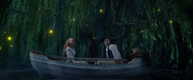 Ariel and Prince Eric in boat in a lagoon.