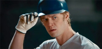 Colin Ford plays Rickey Hill. Teen boy with batting baseball cap on holding the rim of his cap.