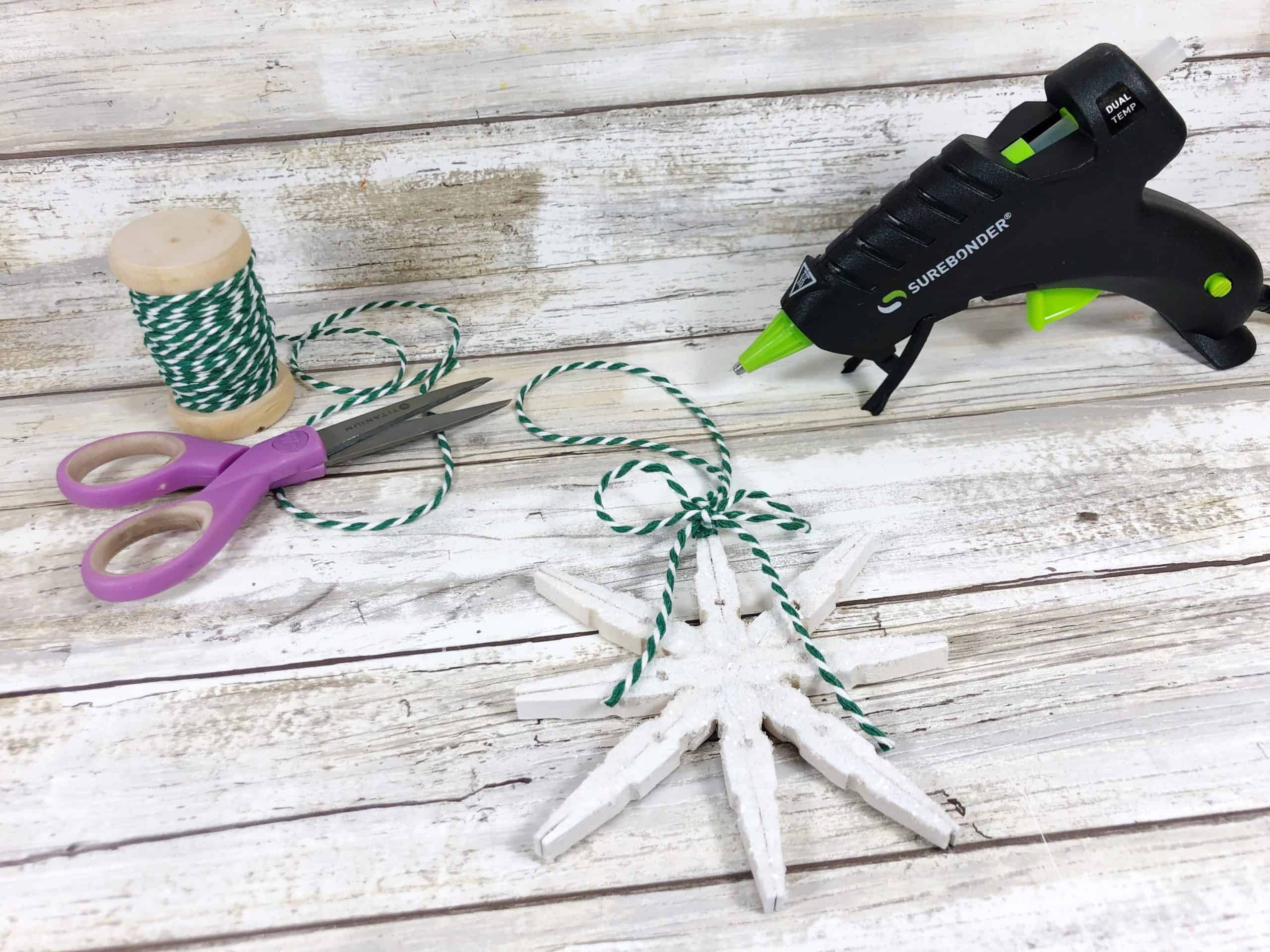 Snowflake ornament, twine, scissors and hot glue gun