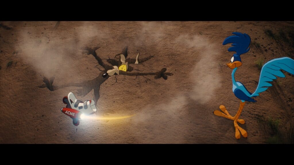 Wile E. Coyote in the ground with Road Runner standing over him