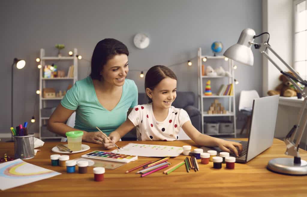 Mom and daughter doing an art project and looking at a computer screen